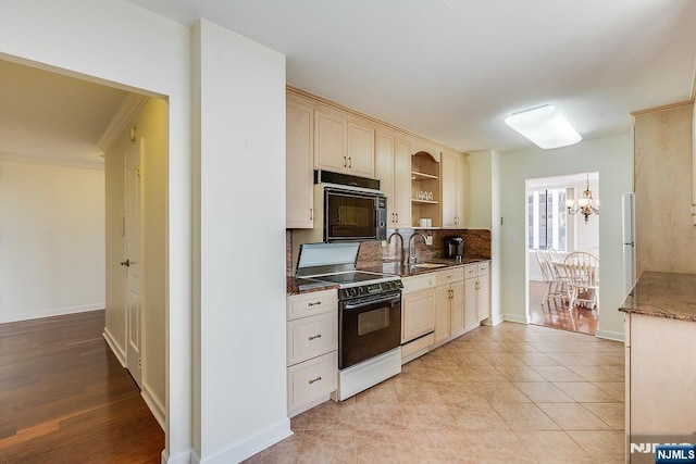 300 Winston Dr Unit 1817, Cliffside Park, NJ 07010 - kitchen with black appliances, a sink, a chandelier, tasteful backsplash, and baseboards