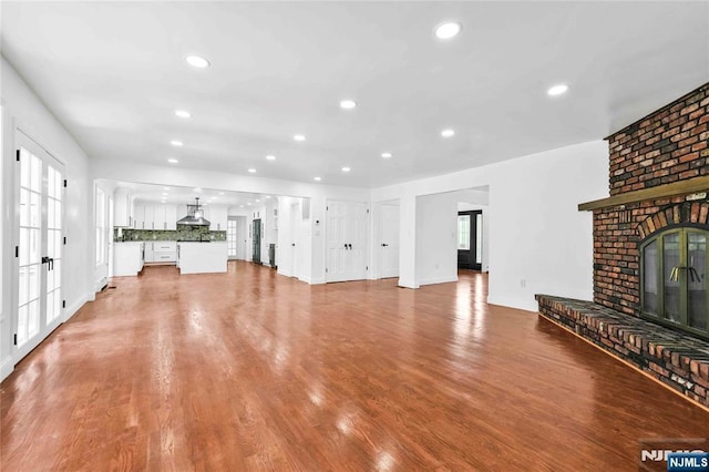11 Deer Meadow Rd, Warwick, NY 10990 - unfurnished living room featuring a fireplace, recessed lighting, french doors, healthy amount of natural light, and wood finished floors