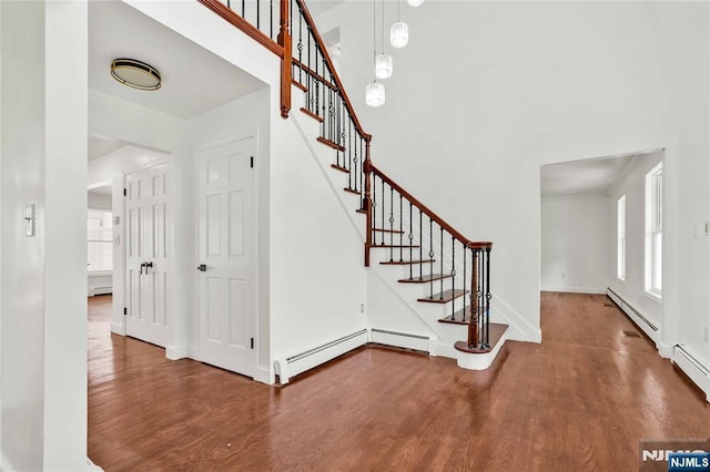 11 Deer Meadow Rd, Warwick, NY 10990 - stairs featuring baseboard heating, wood finished floors, baseboards, and a high ceiling