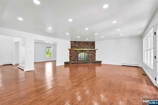 11 Deer Meadow Rd, Warwick, NY 10990 - unfurnished living room featuring a baseboard heating unit, recessed lighting, wood finished floors, a baseboard radiator, and a fireplace