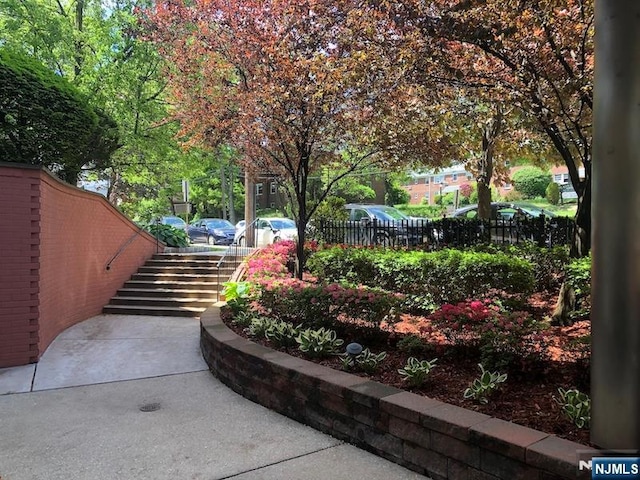 view of home's community featuring stairs and fence