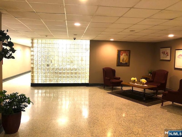 common area with a paneled ceiling