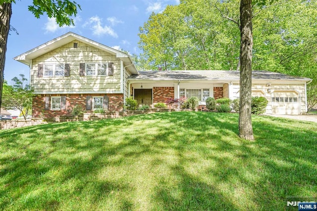 tri-level home with a garage, a front yard, brick siding, and concrete driveway