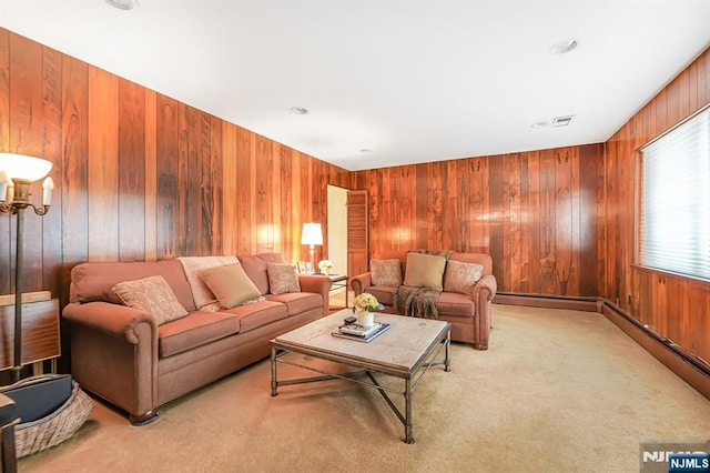 living room featuring wood walls, light carpet, and baseboard heating
