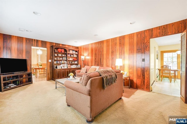 living area with wood walls and light colored carpet