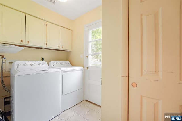 laundry room with cabinet space, washer and clothes dryer, and light tile patterned floors