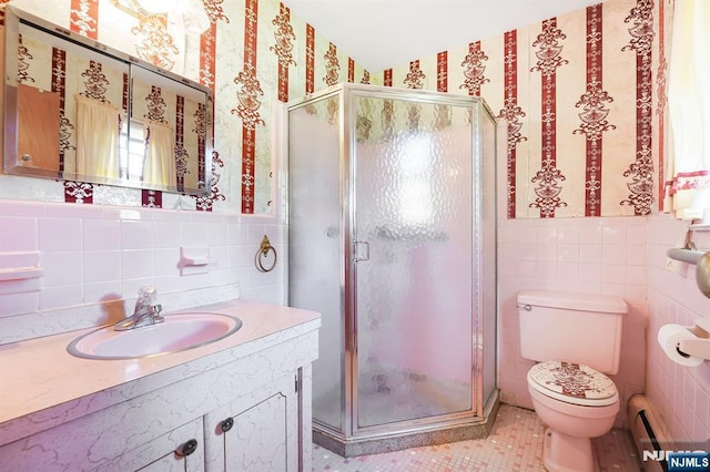 full bathroom featuring tile walls, a stall shower, toilet, a baseboard radiator, and tile patterned flooring