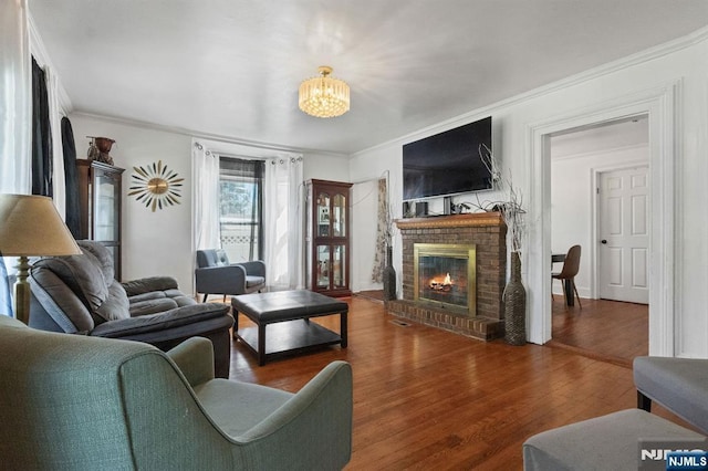 218 Waldo Pl, Englewood, NJ 07631 - living room with a chandelier, a fireplace, wood finished floors, and ornamental molding