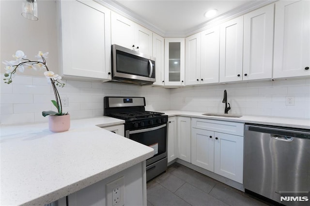 155 Liberty Rd, Teaneck, NJ 07666 - kitchen with stainless steel appliances, a sink, white cabinets, and decorative backsplash