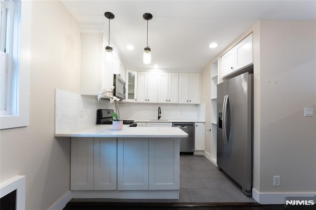 155 Liberty Rd, Teaneck, NJ 07666 - kitchen with stainless steel appliances, a peninsula, a sink, light countertops, and white cabinets