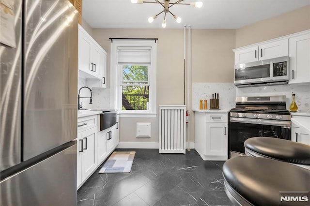 kitchen featuring stainless steel appliances, a chandelier, light countertops, and tasteful backsplash