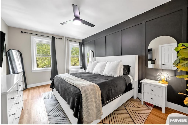bedroom featuring light wood finished floors, baseboards, and ceiling fan