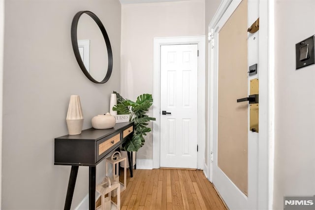 doorway featuring light wood finished floors and baseboards