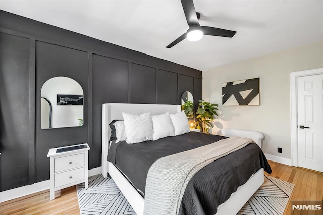bedroom with light wood-style flooring, baseboards, and ceiling fan