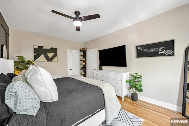 bedroom with light wood-type flooring, baseboards, and a ceiling fan