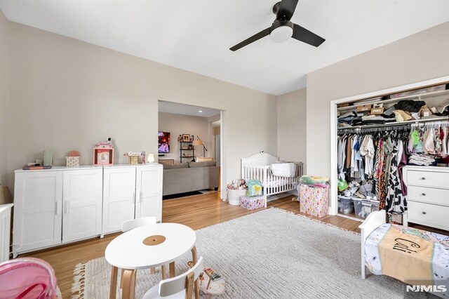 bedroom with light wood finished floors, a closet, and a ceiling fan