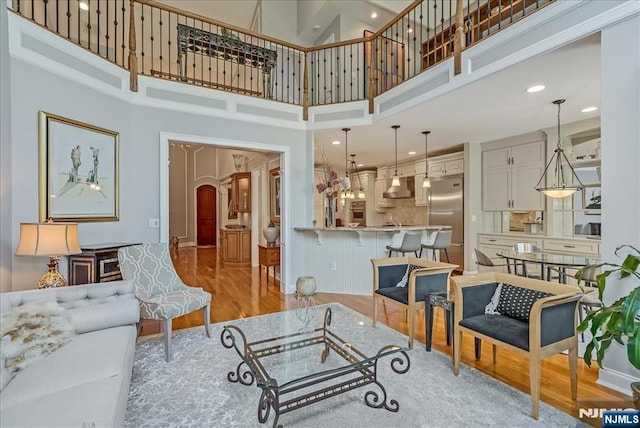 75 Windsor Ln, Ramsey, NJ 07446 - living room featuring a towering ceiling, light wood finished floors, arched walkways, and recessed lighting