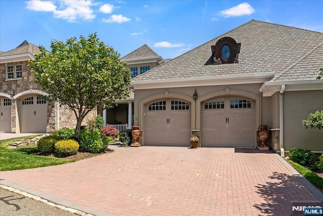 75 Windsor Ln, Ramsey, NJ 07446 - french country style house featuring a garage, stucco siding, decorative driveway, a high end roof, and stone siding