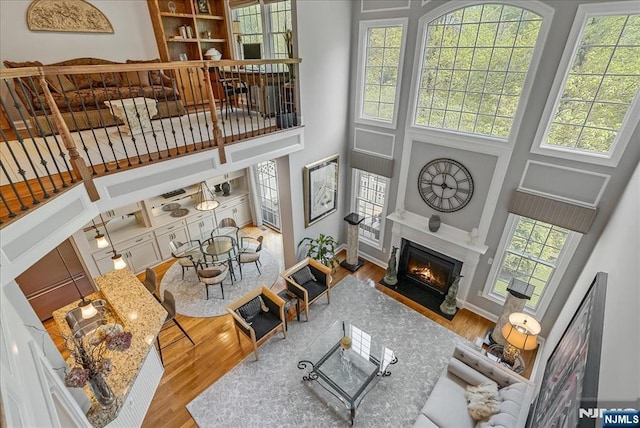 75 Windsor Ln, Ramsey, NJ 07446 - living area with a high ceiling, wood finished floors, a fireplace with flush hearth, and baseboards