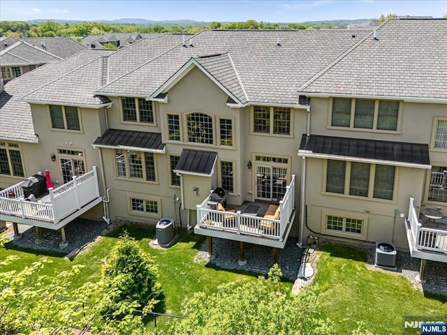 75 Windsor Ln, Ramsey, NJ 07446 - rear view of property with a standing seam roof, stucco siding, and a wooden deck