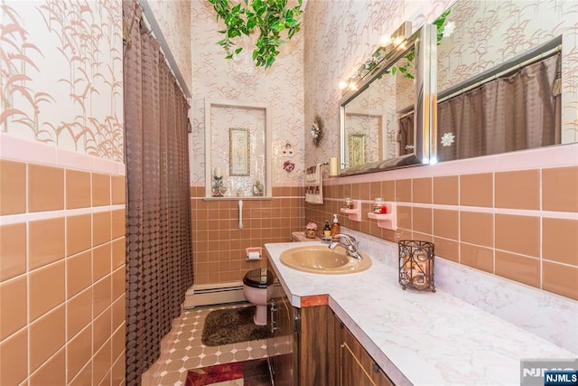 full bathroom with wallpapered walls, a baseboard radiator, toilet, tile walls, and wainscoting
