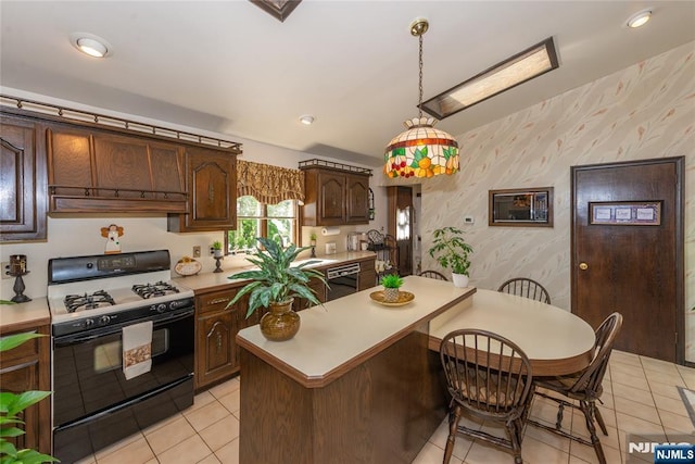 kitchen with gas stove, wallpapered walls, light countertops, under cabinet range hood, and light tile patterned floors