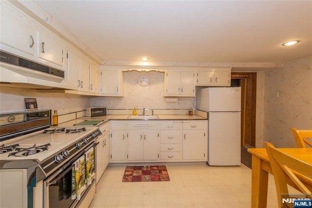 kitchen with white appliances, under cabinet range hood, a sink, white cabinetry, and light floors