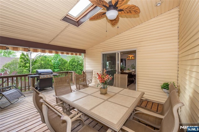 deck featuring outdoor dining area, area for grilling, and a ceiling fan