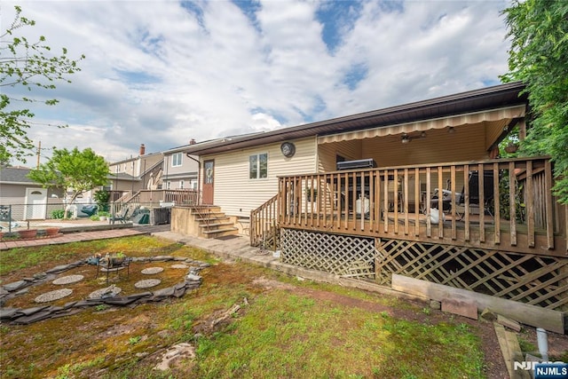 back of property featuring a deck, stairway, and fence