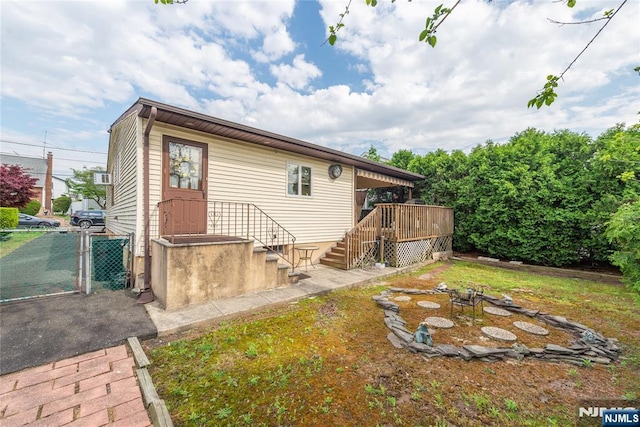 back of house featuring a gate, fence, stairway, and a wooden deck