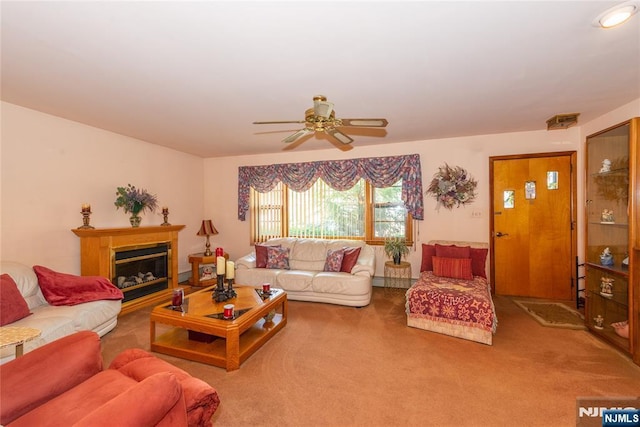 living room featuring ceiling fan, carpet flooring, and a glass covered fireplace