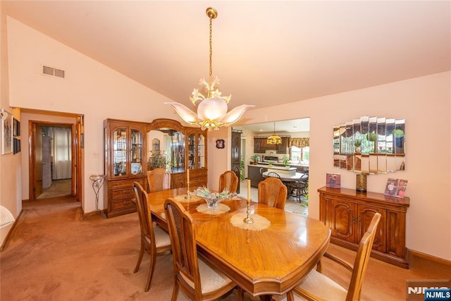 dining area with light carpet, a chandelier, high vaulted ceiling, and baseboards
