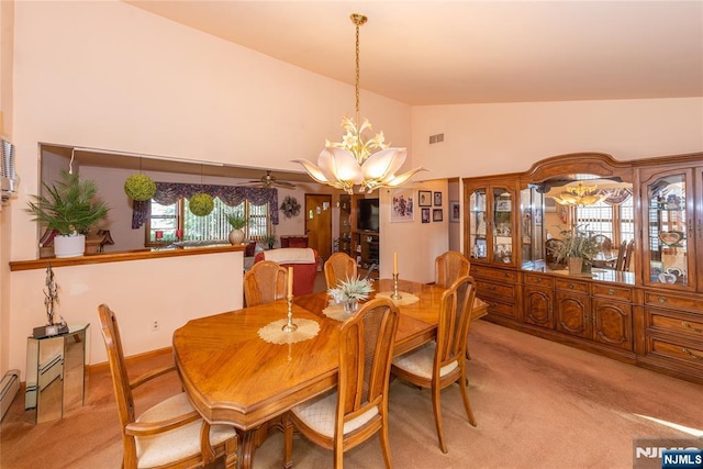 dining room featuring light colored carpet, a chandelier, high vaulted ceiling, and a ceiling fan