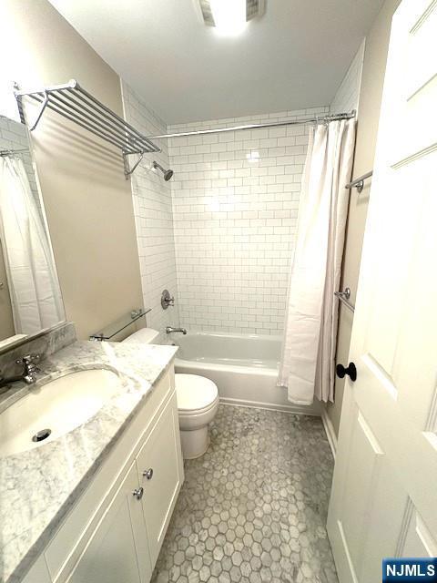 full bathroom featuring shower / tub combo, vanity, and toilet