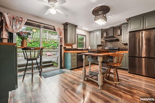 11 Beech Ct, Ringwood, NJ 07456 - kitchen with appliances with stainless steel finishes, wall chimney exhaust hood, wooden counters, backsplash, and light wood finished floors