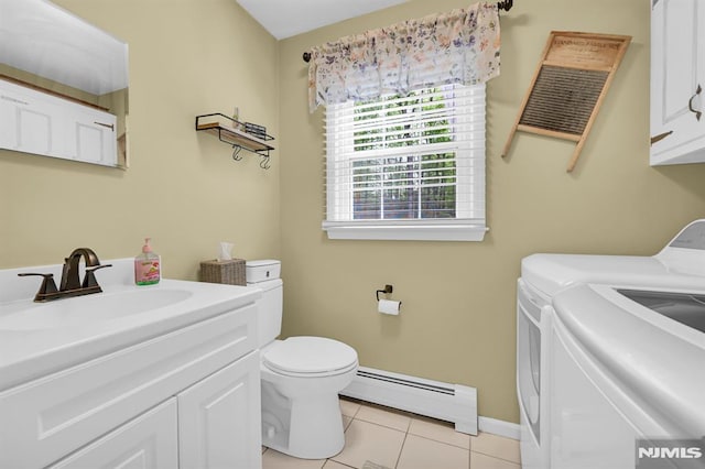 bathroom with baseboard heating, washer and clothes dryer, tile patterned flooring, toilet, and baseboards