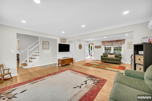 living area featuring wood finished floors, stairway, crown molding, baseboards, and recessed lighting
