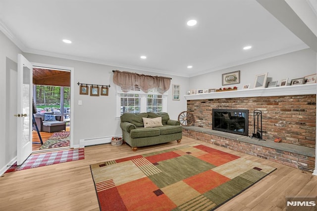 living room featuring wood finished floors, crown molding, a brick fireplace, baseboards, and baseboard heating