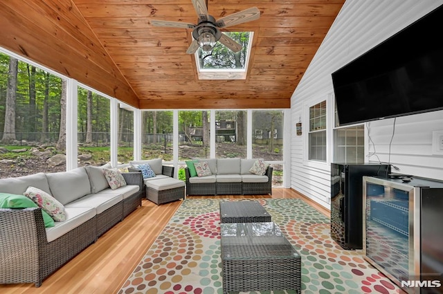 sunroom with an outdoor living space, vaulted ceiling, a ceiling fan, and a skylight