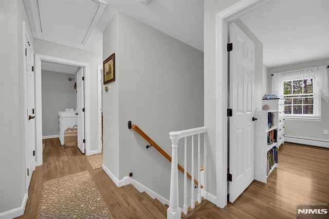 hallway featuring an upstairs landing, attic access, wood finished floors, and baseboards
