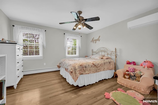 bedroom with a baseboard radiator, an AC wall unit, light wood finished floors, ceiling fan, and baseboards