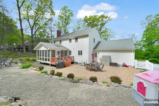 back of house featuring a sunroom, a patio area, fence, a gate, and a deck