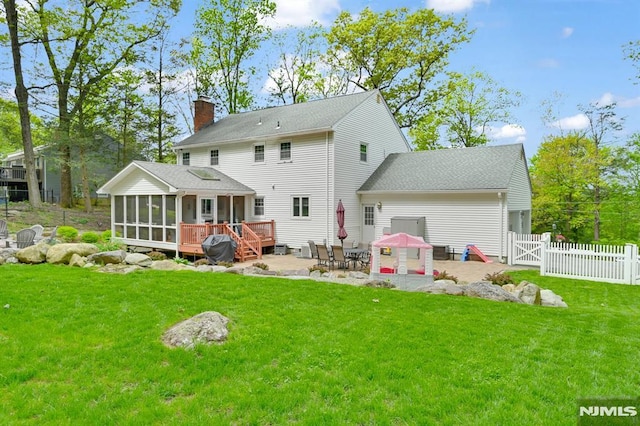 rear view of property with a sunroom, a patio, a chimney, and a gate