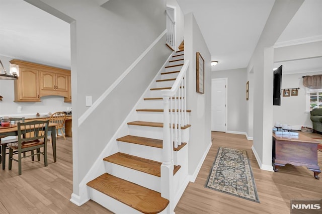 staircase with wood finished floors and baseboards