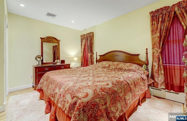 bedroom featuring wood finished floors, recessed lighting, a baseboard heating unit, and baseboards