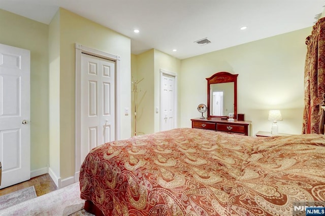 bedroom featuring wood finished floors, recessed lighting, a closet, and baseboards