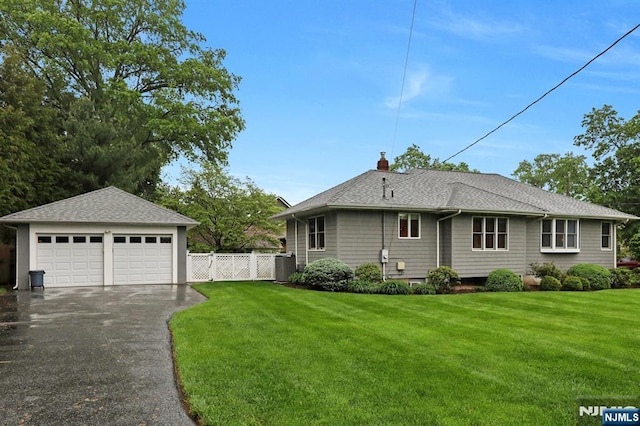 view of front of house featuring a detached garage, a chimney, a shingled roof, central AC, and an outdoor structure