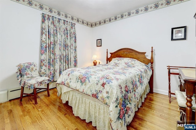 bedroom with wood finished floors and baseboards
