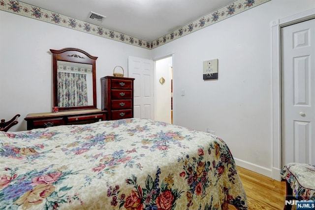 bedroom with wood finished floors and baseboards
