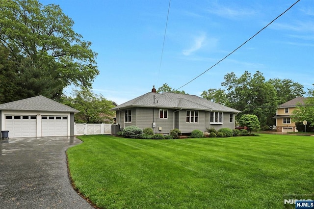 view of front of house featuring a garage, a shingled roof, and an outdoor structure